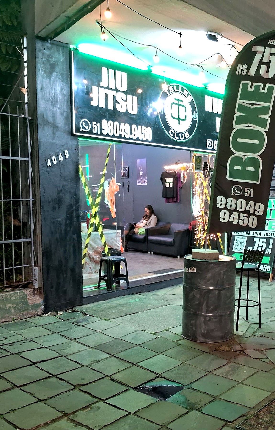 Fachada iluminada da Telles Club na Av. Assis Brasil